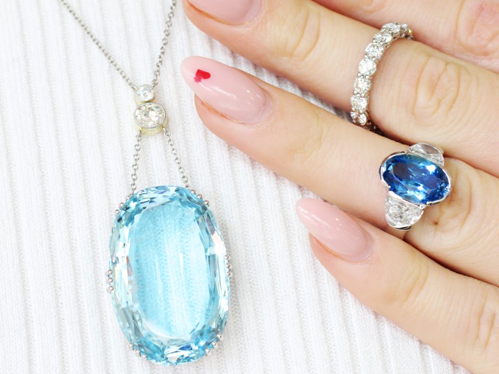 wearing large aquamarine necklace and diamond ring 