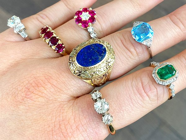 multiple coloured art deco rings being worn